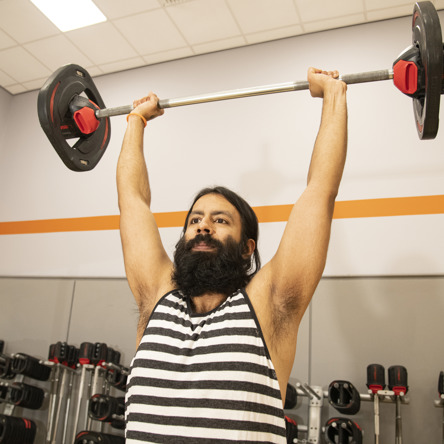 A person doing overhead press in Body Pump class