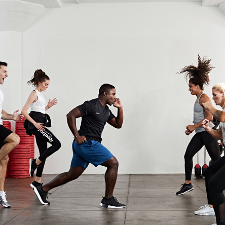 A group of people in a fitness studio lunging in body attack class 