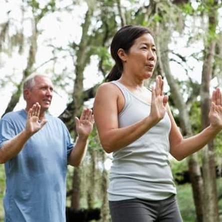 Two people outside holding palms out in front with arms bent