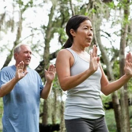 Two people outside holding palms out in front with arms bent 