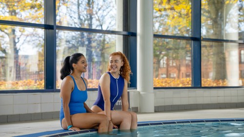 Two Glasgow Club members sit at the poolside in Glasgow Club Bellahouston