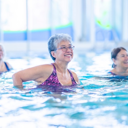 Older group of adults in pool taking part in Aqua Zumba class.