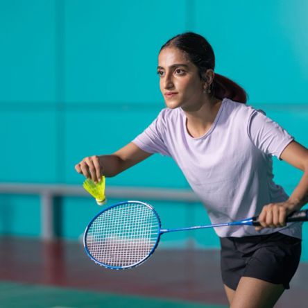 A person getting ready to serve in a game of badminton