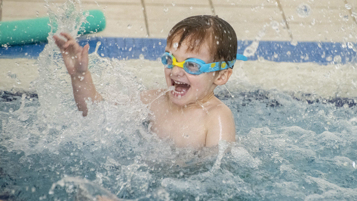 A child splashing and having fun in pool.