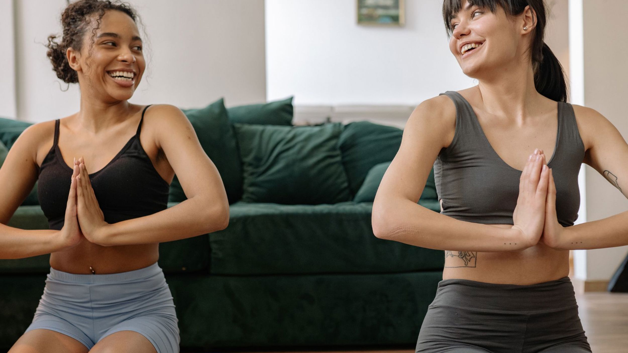 Two people doing a yoga workout in a home living room