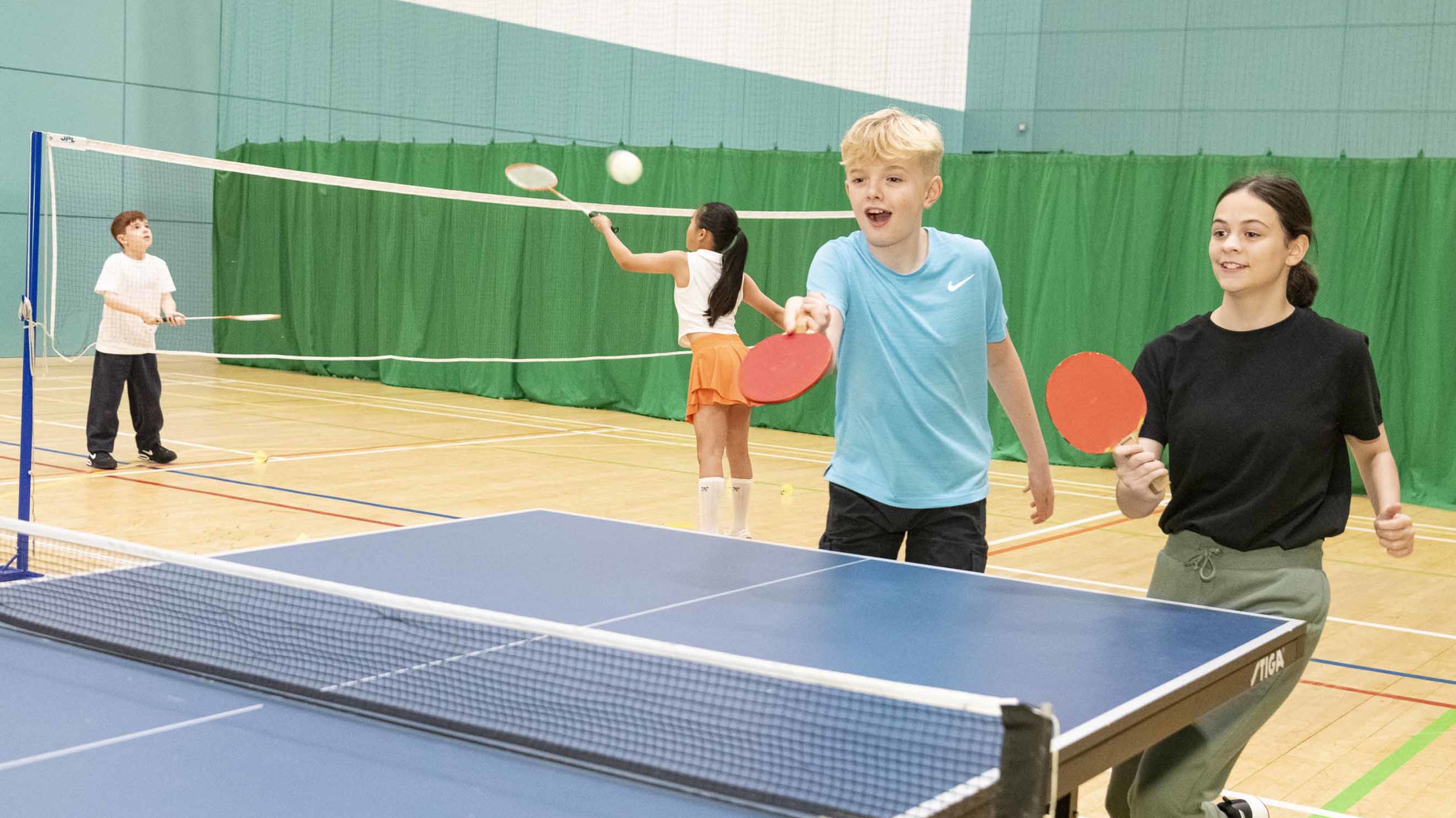 Two children play table tennis. 