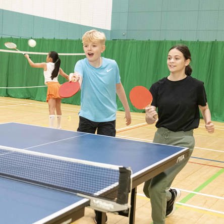 Two children play table tennis. 