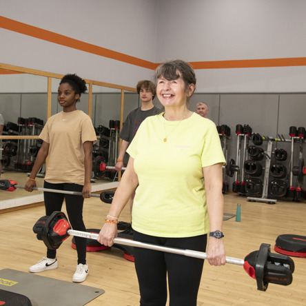 a group of adults holding bar bells during body pump technique class