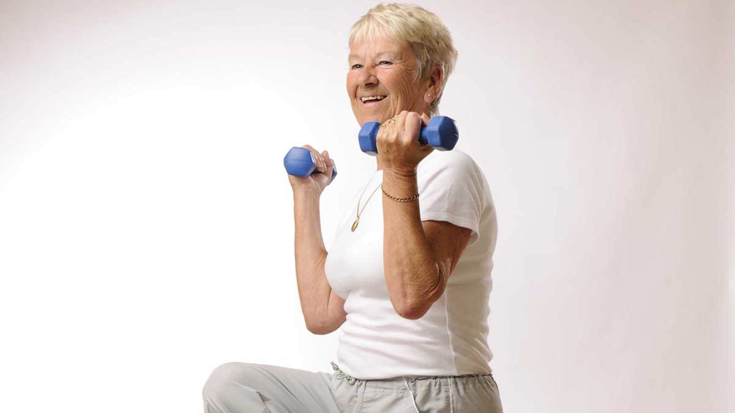 Person smiling holding light weights 
