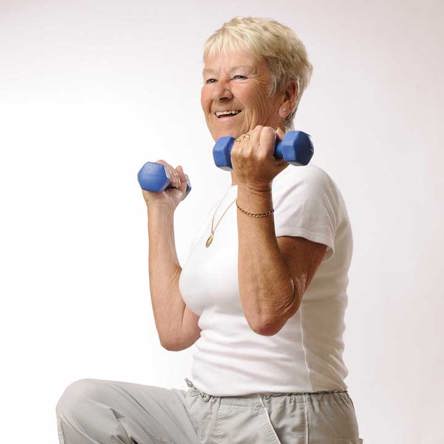 Person smiling holding light weights 