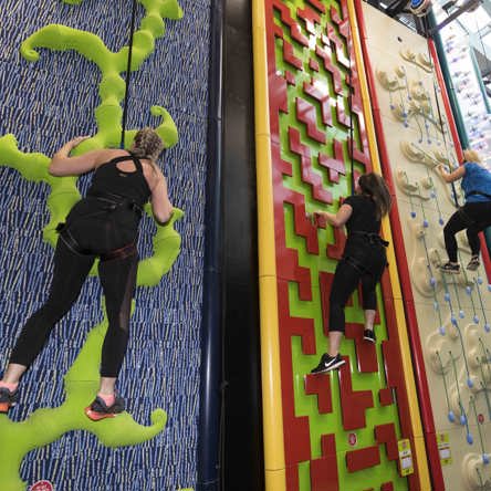 Three people at different heights on climbing wall 