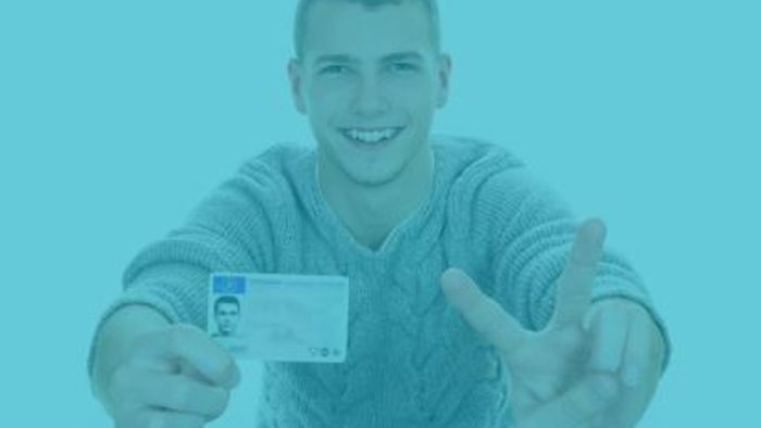 A young person showing an ID card proving their age